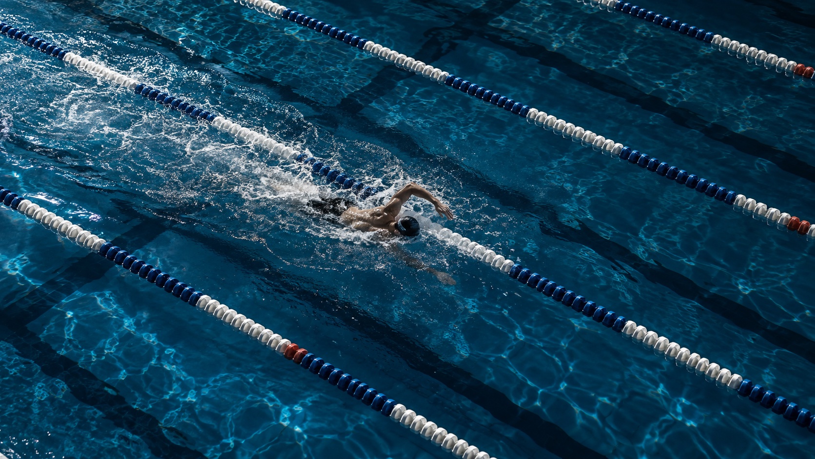Swimming pool artwork with a freestyle swimmer between blue lane ropes